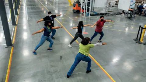 East Riding of Yorkshire Council Five people taking part in an exercise class on a factory floor