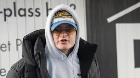 A young man called Marius Borg Hoiby wearing warm clothes and a cap and sunglasses