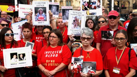 Reuters People impacted by the contaminated blood scandal gather in Westminster for a vigil to remember those that lost their lives, ahead of the release of the final report of the Infected Blood Inquiry on Monday, in London