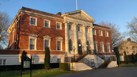 The two-storey, red brick Warrington Town Hall on a sunny day. 