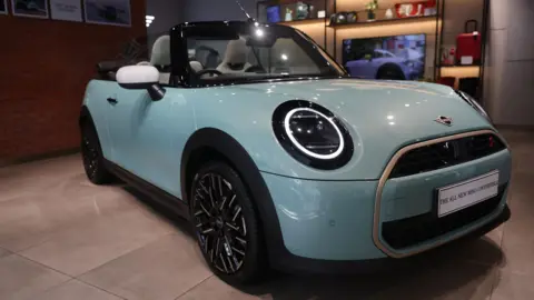 Reuters A Mini Cooper convertible is displayed at a BMW showroom in Mumbai, India, January 8, 2026.