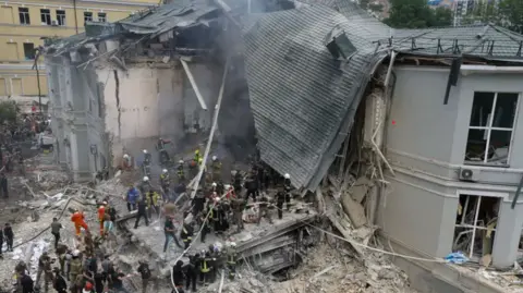 EPA Rescue teams work in the rubble of the badly-damaged hospital