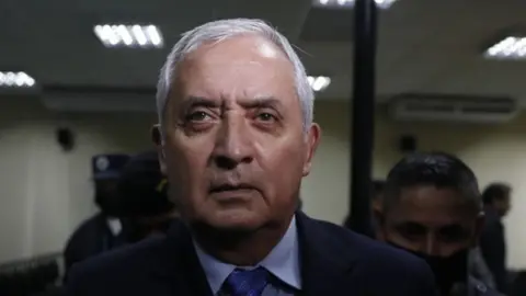 Getty Images Guatemalan former President Otto Perez Molina, who sentence to 16 years, leaves at the court with police members after his trial in Guatemala City, Guatemala on December 07, 2022