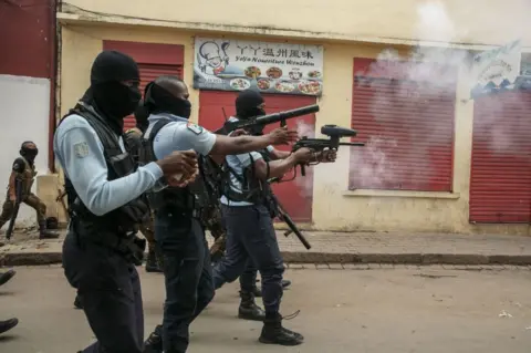 RIJASOLO/AFP Security officers fire tear gas as they clash with demonstrators.