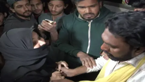 Social media A woman grasps the man's hands surrounded by a crowd