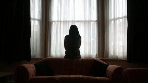 Generic image of a woman looking out a window