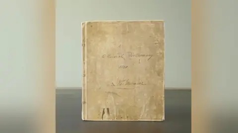 Hansons Auctioneers An image of a dictionary from the 19th century which is light brown in colour