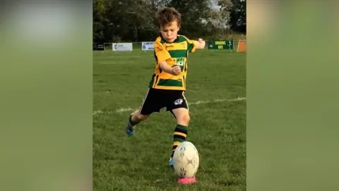 Seven-year-old Oscar kicking rugby ball