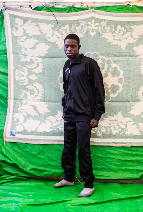 Marcus Drinkwater Omer Ali stands with his fist clenched against a background