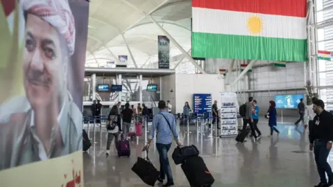 Getty Images People are seen inside Irbil International Airport on 27 September 2017