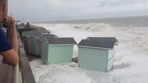 Cheryl Fletcher Beach huts lifted and washed down the beach by the waves