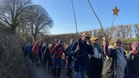 People walk on road holding signs