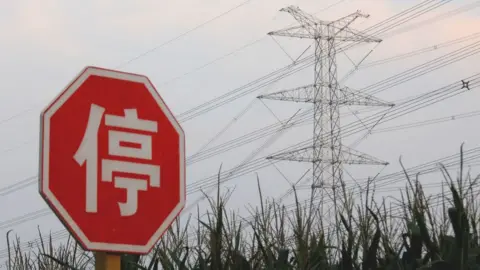 Getty Images A 'Stop' sign in Chinese next to an electricity pylon in Beijing, China.