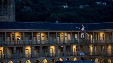 Charlotte Graham Man walking on a tightrope at The Piece Hall in Halifax