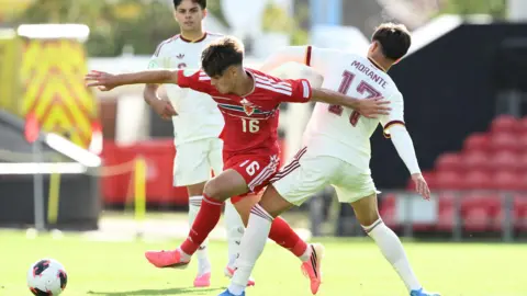 Robert Tankiewicz of Wales evades the challenge of Spain's Jose Antonio Morante