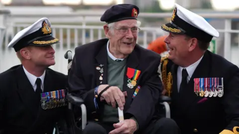 PA (Left to right) Royal Navy Commander Glenn Higson, D-Day veteran Jim Grant and Royal Navy Commodore John Voyce
