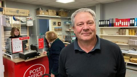 Roger Tripp in a temporary Post Office in Framlingham