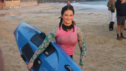 Teenage paddleboarder on beach 