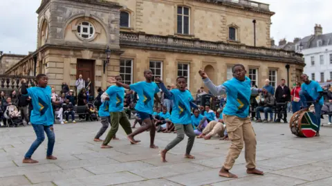Carla Mabb The choir performing in Bath City Centre. They are performing outside the Roman Baths.