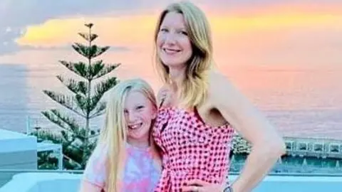 Rebecca Hitchen and her daughter, Lucia in front of a sunset