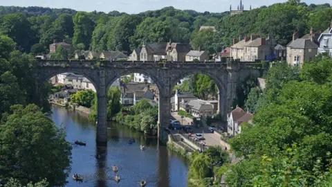 PA Media Knaresborough view from the sky: an aqueduct stretched over the river while people row boats below.