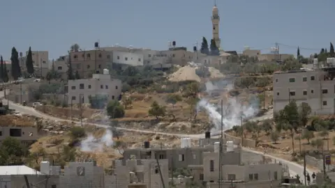 A cloud of tear gas rises from a field in the village of al-Mughayyir, near Ramallah, in the Israeli-occupied West Bank (11 July 2026)