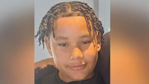 Wivenhoe Town FC/Facebook A close-up image of Taylen who is smiling and looking at the camera. He has a middle parting and has plaited hair to his ear.