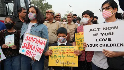 NurPhoto via Getty Images Women and children hold placards to protest against the hazardous air pollution situation in New Delhi, India, on November 9, 2025. (Photo by Bilal Kuchay/NurPhoto via Getty Images)