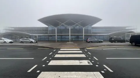 The front of a small airport on a foggy day.
