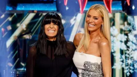 TV presenters Claudia Winkleman (l) and Tess Daly (r) on the BBC Strictly set during the 2024 Christmas special.