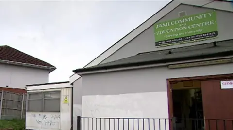 Jami Community and Education Centre The outside of a mosque with graffiti sprayed on to say "no one wants you here"
