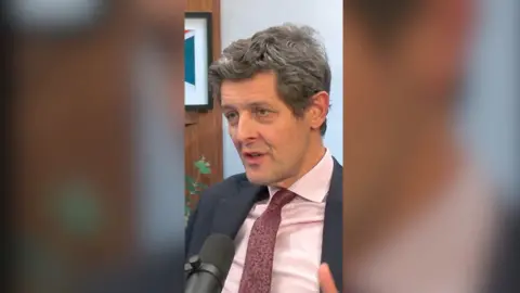 Hugh Pym in the Newscast studio