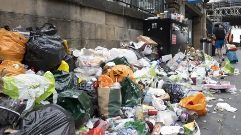PA Media Large piles of bin bags and rubbish on the pavement.