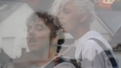 Dylan Holloway A screenshot of the music video showing Dylan and Lots