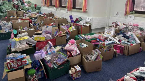 Dozens of boxes filled with toys that are organised into lines. The toys include 