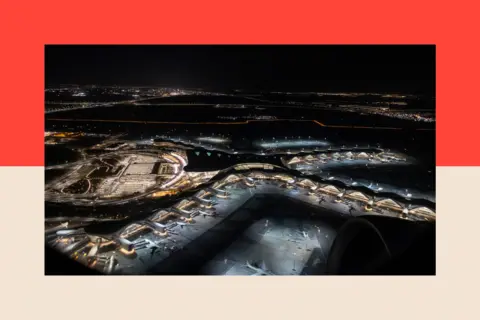 NurPhoto via Getty Images An aerial night view from a departing airplane window shows h multiple aircrafts parked at the Zayed International Airport.