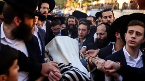 Reuters Mourners carry the body of Aryeh Schupak, 15, at his funeral in Jerusalem (23 November 2022)