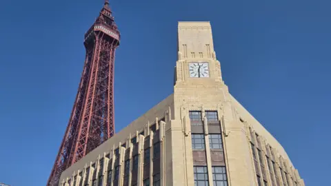 Blackpool Tower next to Art Deco building with a tiled facade and a clock tower