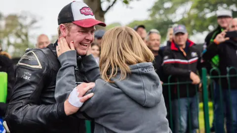 MANX GRAND PRIX An emotional Daniel Ingham being embraced by his wife after the race.