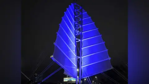 Portsmouth’s Sails of the South sculpture lit up in blue lights.