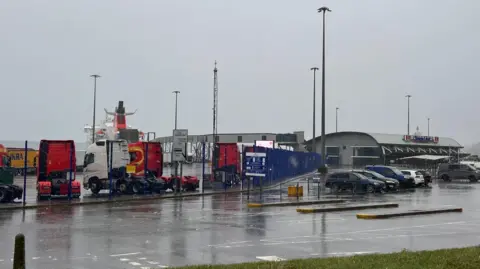 The Cairnryan ferry port with a ferry stuck in harbour due to bad weather and lorries and cars parked up outside