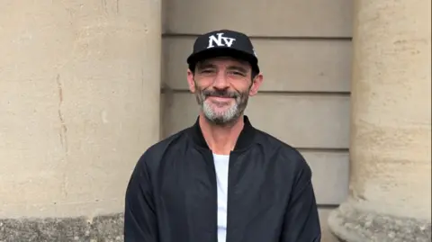 Bristol Drugs Project Paul Jennings wearing a baseball cap and a black jacket and looking at the camera