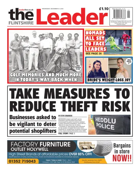 The Flintshire Leader Front page of the Flintshire Leader with the main headline: "Take measures to reduce theft risk", under which is the sub-head: "Businesses asked to be vigilant to deter potential shoplifters", and an image of the back of a police jacket with the words Heddlu/Police in white text. Above is a black and white image of golfers with the headline: "golf memories and much more in today's way back when." To the right of this is an image of two people playing football with the headline: "Nomads all set to face leaders" and under this is a composite image of a woman, one of the pics she is in a wedding dress, with the headline "Bride's weightloss joy".