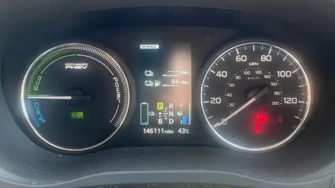 A car dashboard showing 43C on the temperature.