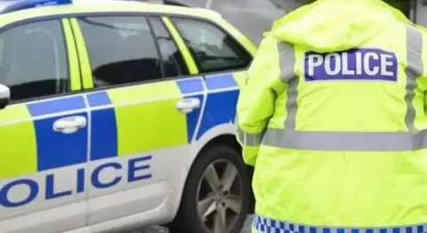 BBC Police car and back of police officer's jacket