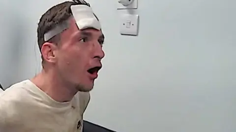 Shouting man with bandaged head.