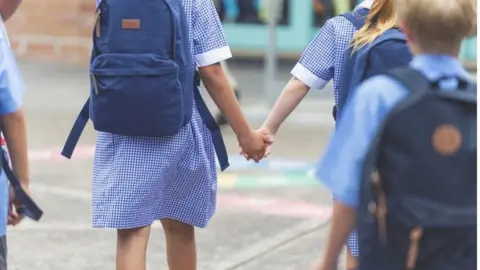 Getty Images Two children holding hands in a play ground