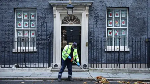 Getty Images A worker sweeps leaves outside 10 Downing Street