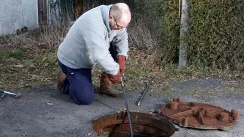 tirc83 Man poking a drain