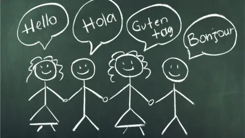 Getty Images A chalk picture of "stick children" saying hello in four languages